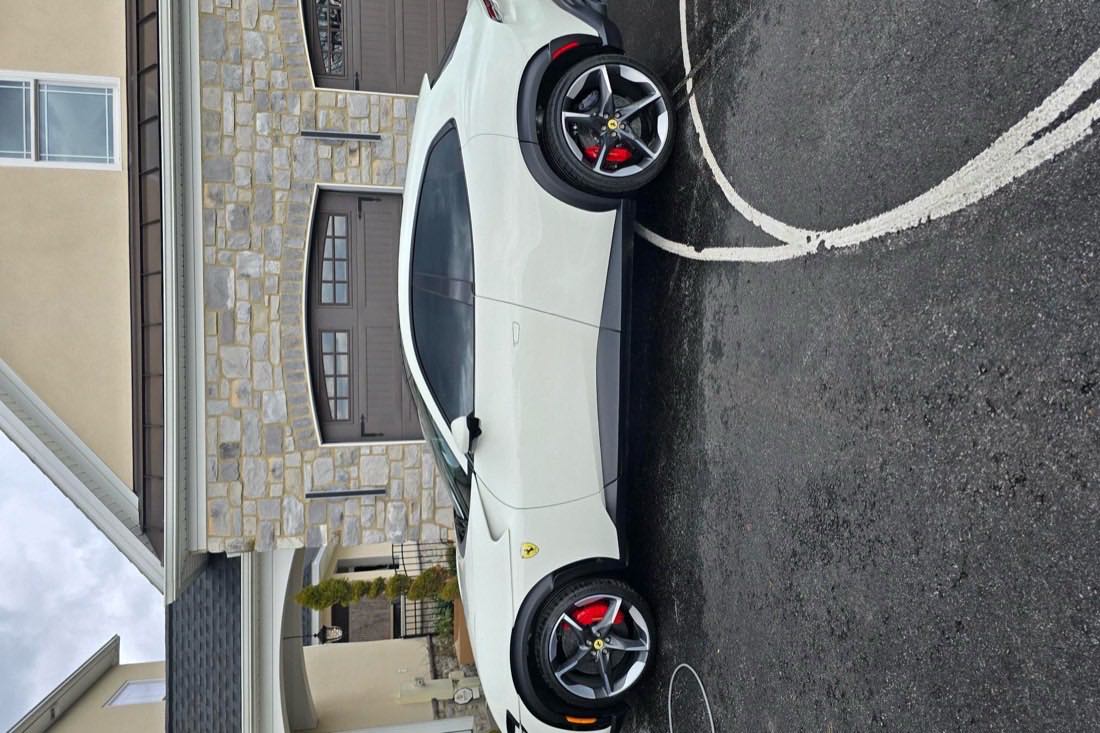White Ferrari parked outside the garage
